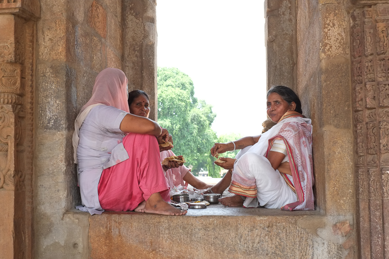 Women eating at the Qutb Menar monument, Delhi, India