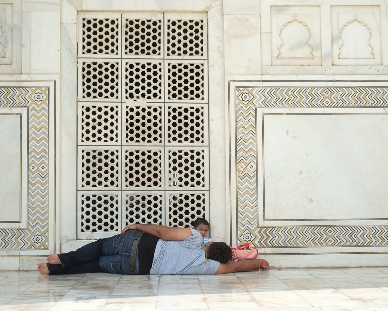 Man and child resting in front of Taj Mahal