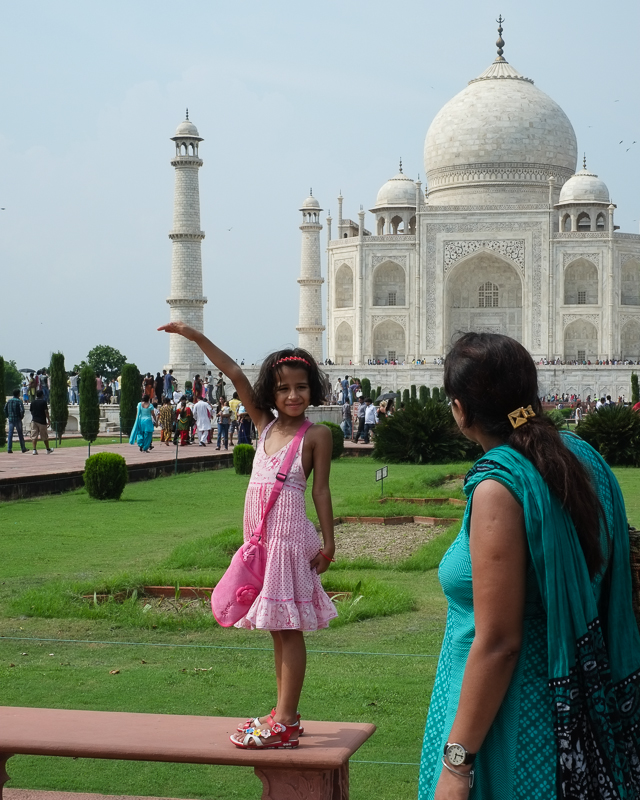 Mother shows her daughter how to pose in front of Taj Mahal